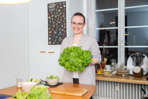 Eine Frau hält einen Kopf grünen Salat