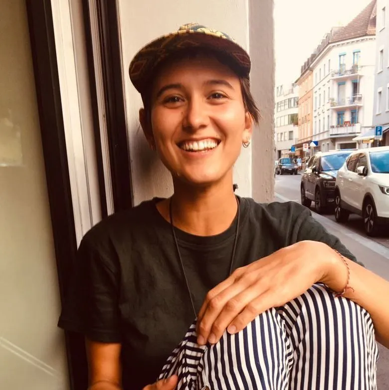 Junge lächelnde Frau sitzt an einem Fenster