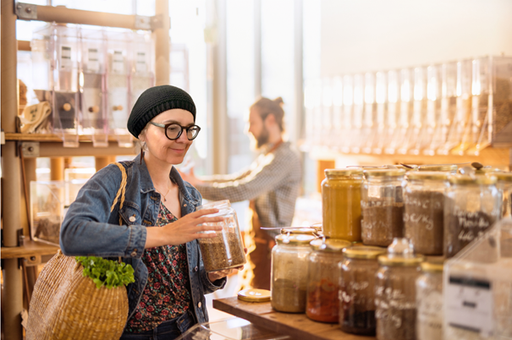 Frau mit Vorratsglas in Unverpacktpladen.