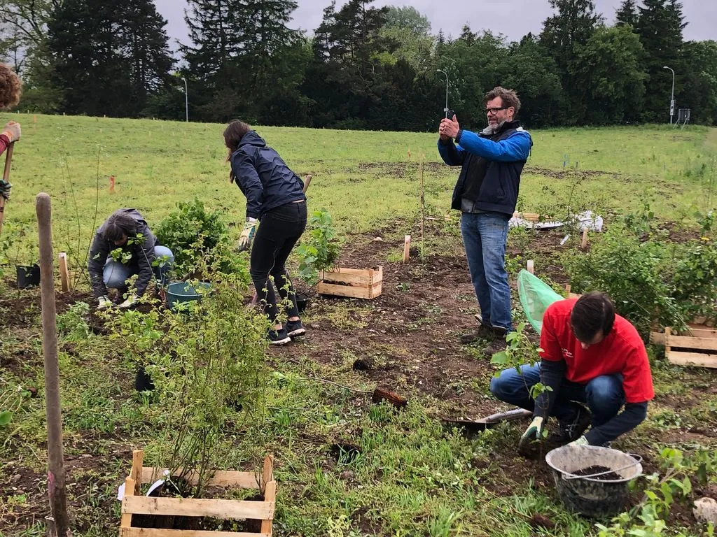 Foto der Story-Erzähler*in mit anderen Menschen beim Pflanzen.