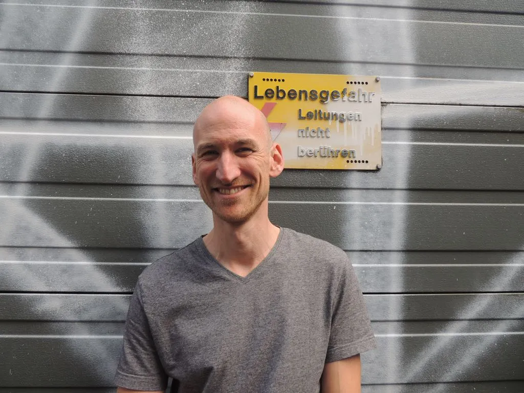 Portrait einer Person vor Wand in einer Stadt.