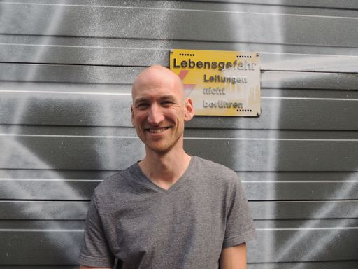 Portrait einer Person vor Wand in einer Stadt.