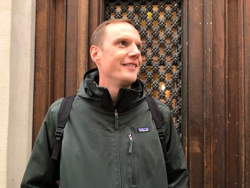 Person steht vor einer Holztür.