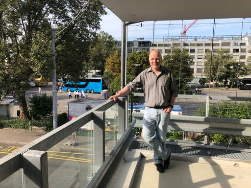 Person auf Balkon in der Stadt.