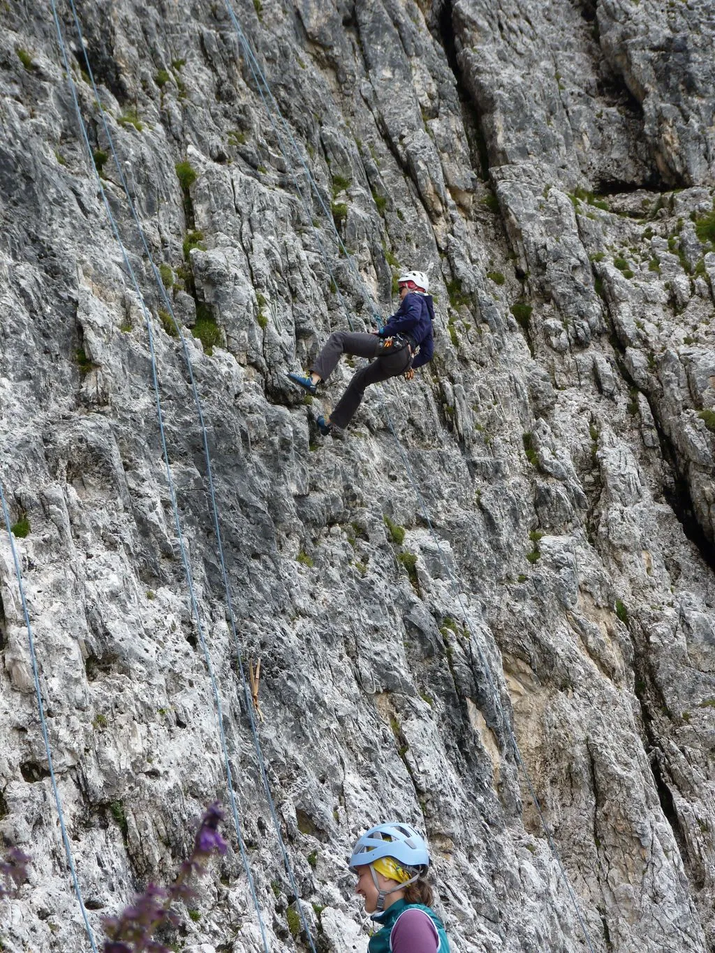 Frau klettert eine Felswand hinauf