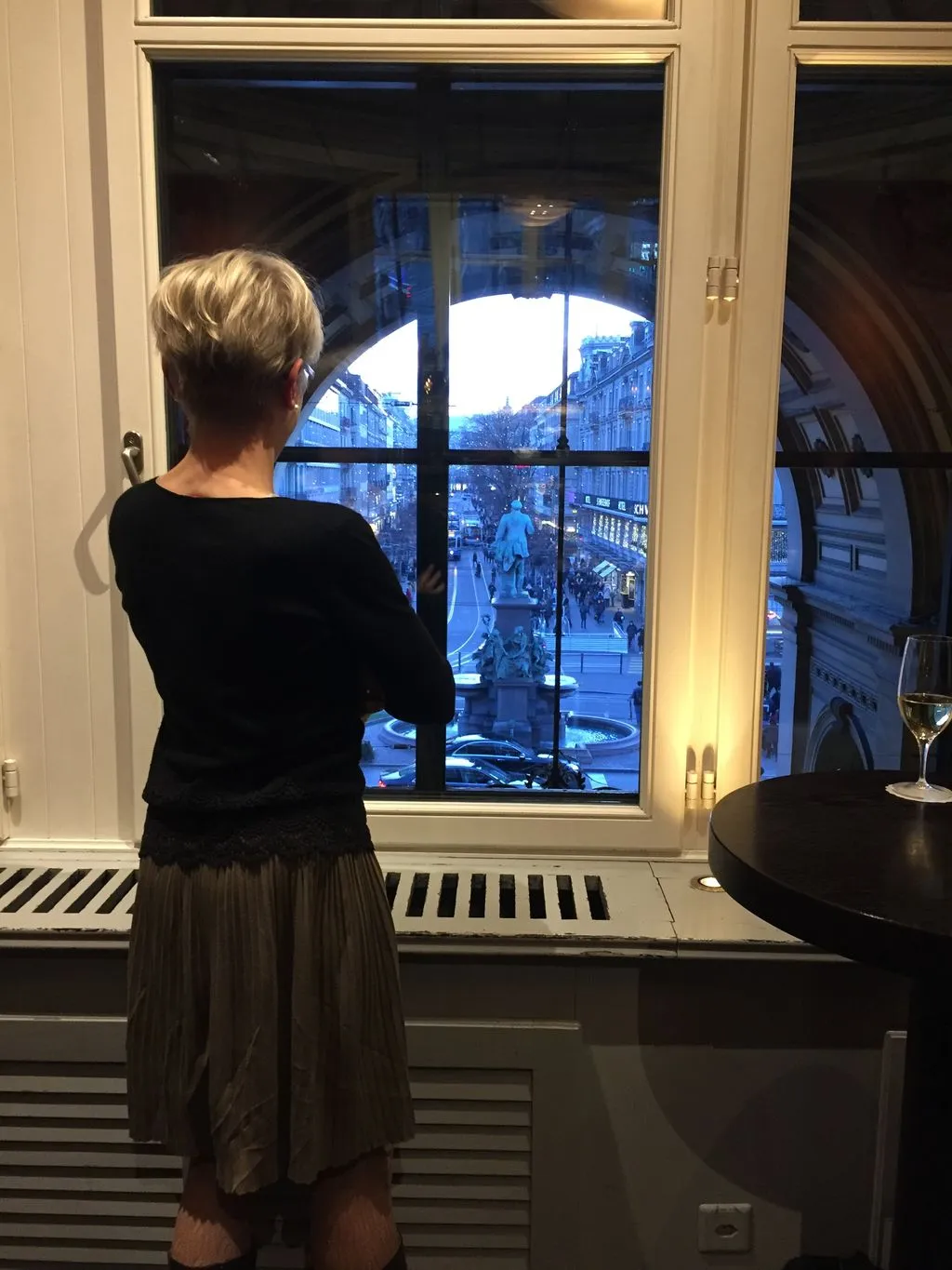 Frau schaut aus dem Fenster.