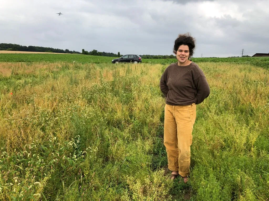 Junge Person steht in einem Linsenacker.