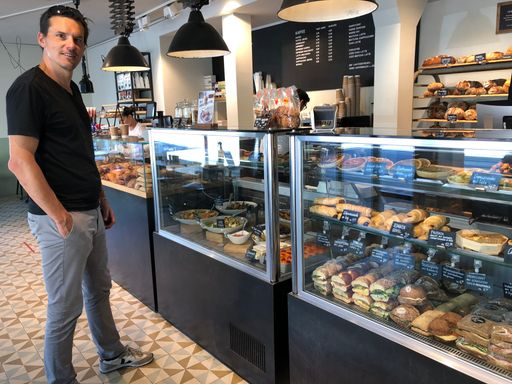 Mann steht in Bäckerei vor Theke.