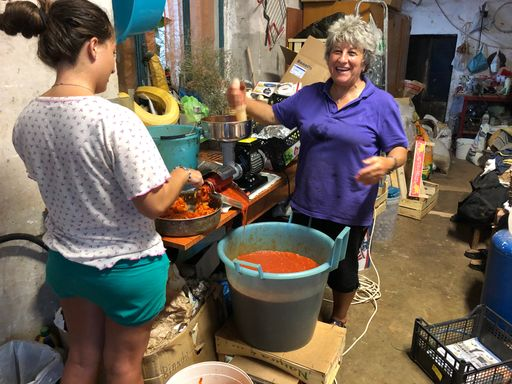 Mutter und Tochter draussen beim Einkochen von Tomatensauce.