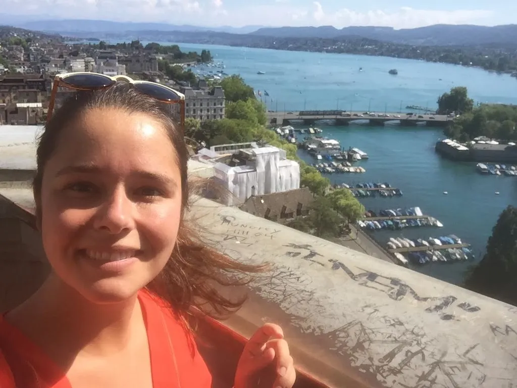 Junge Person mit Stadt- und Seepanorama im Hintergrund.