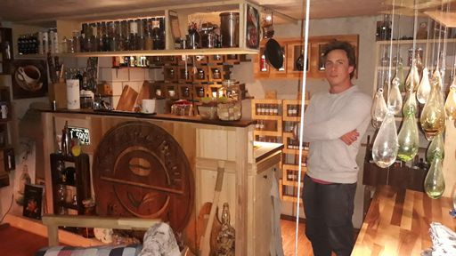 Junger Mann steht neben einer aus Holz gezimmerten Bar