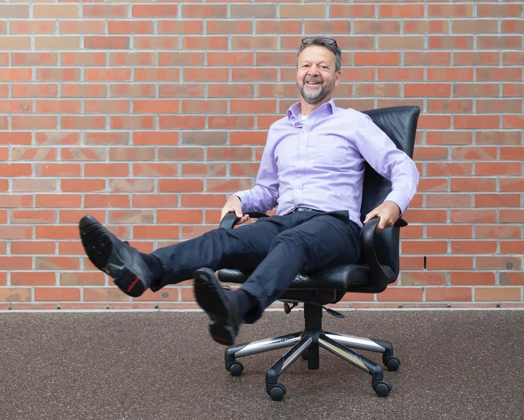 Mann mit erhobenen Beinen auf Bürostuhl