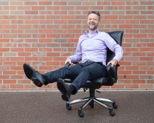 Mann mit erhobenen Beinen auf Bürostuhl