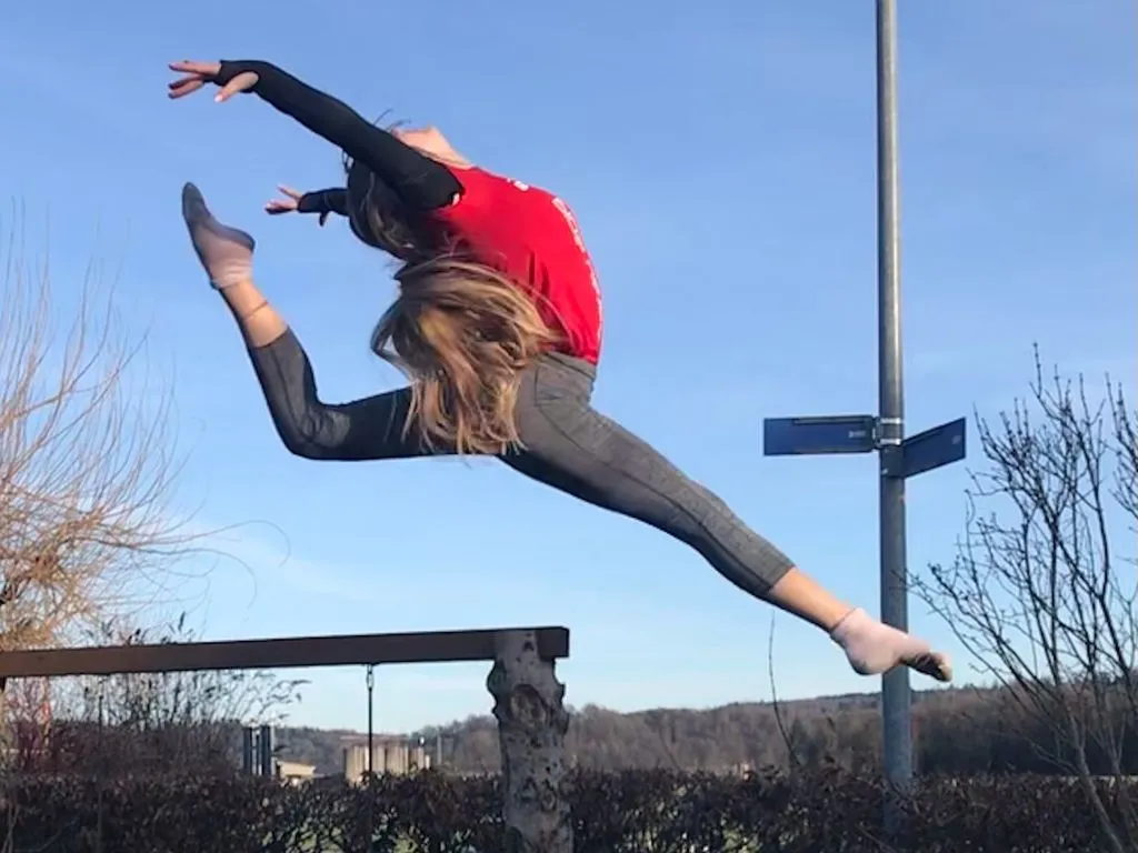 Jugendliche Person mit elegantem Sprung auf Trampoli.